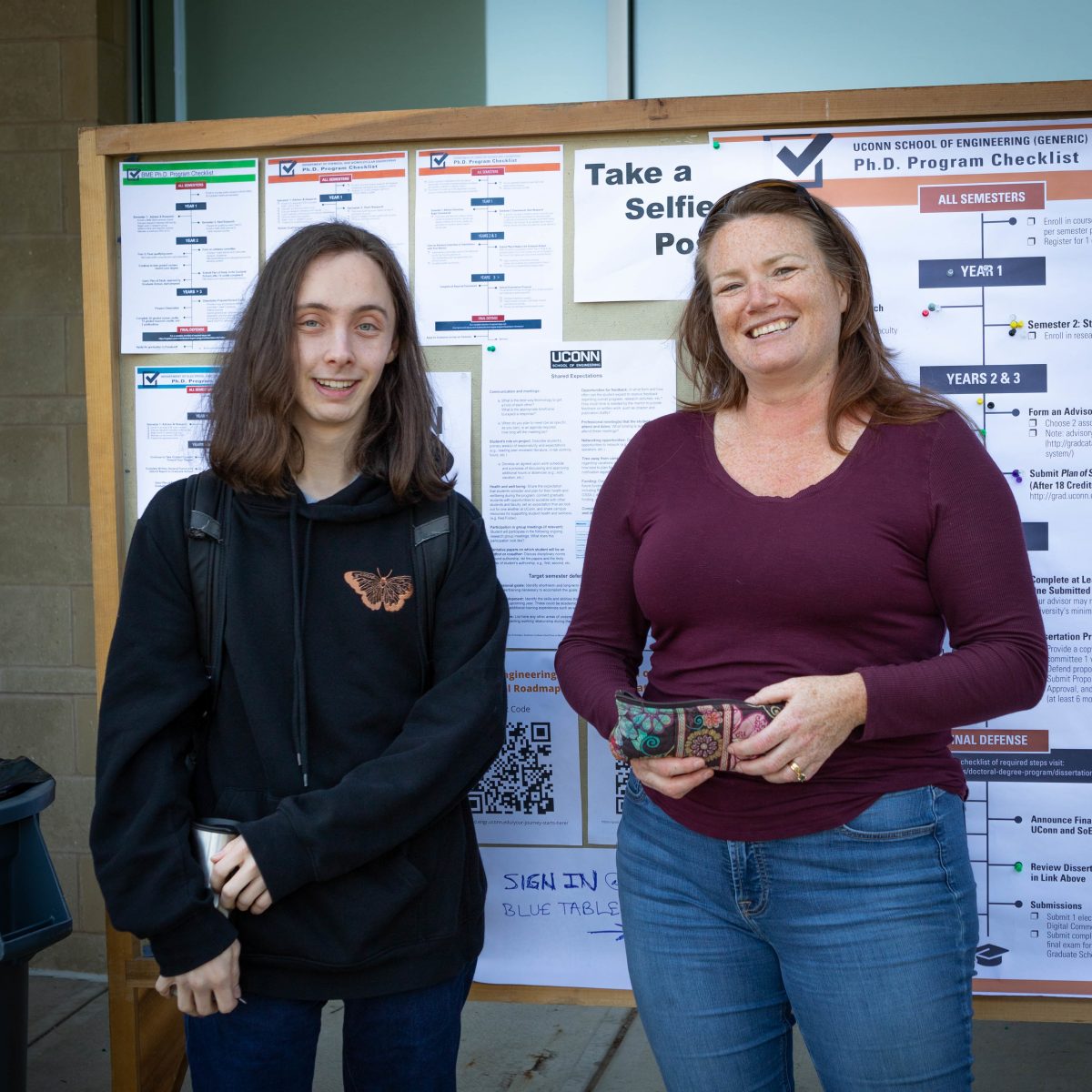 two people standing in front of poster